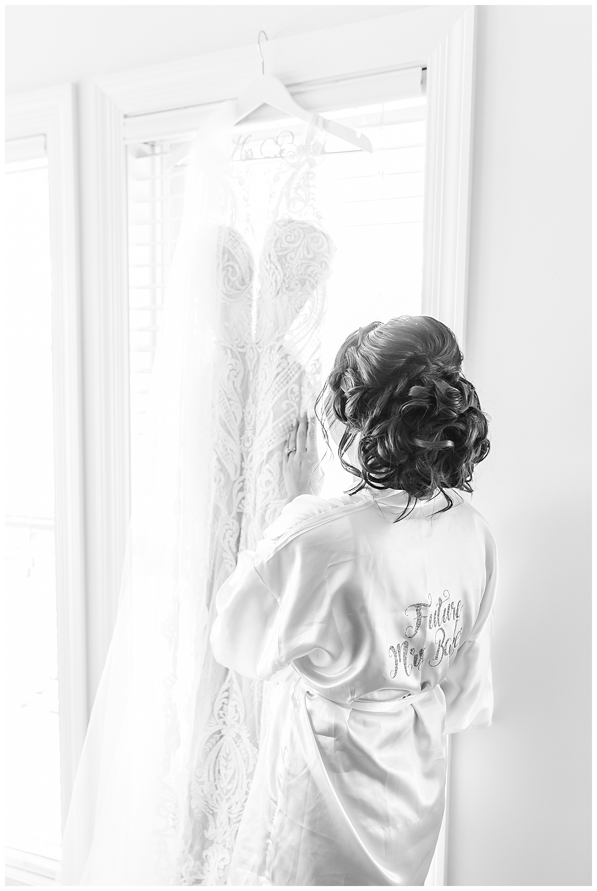 bride looking at wedding dress in robe