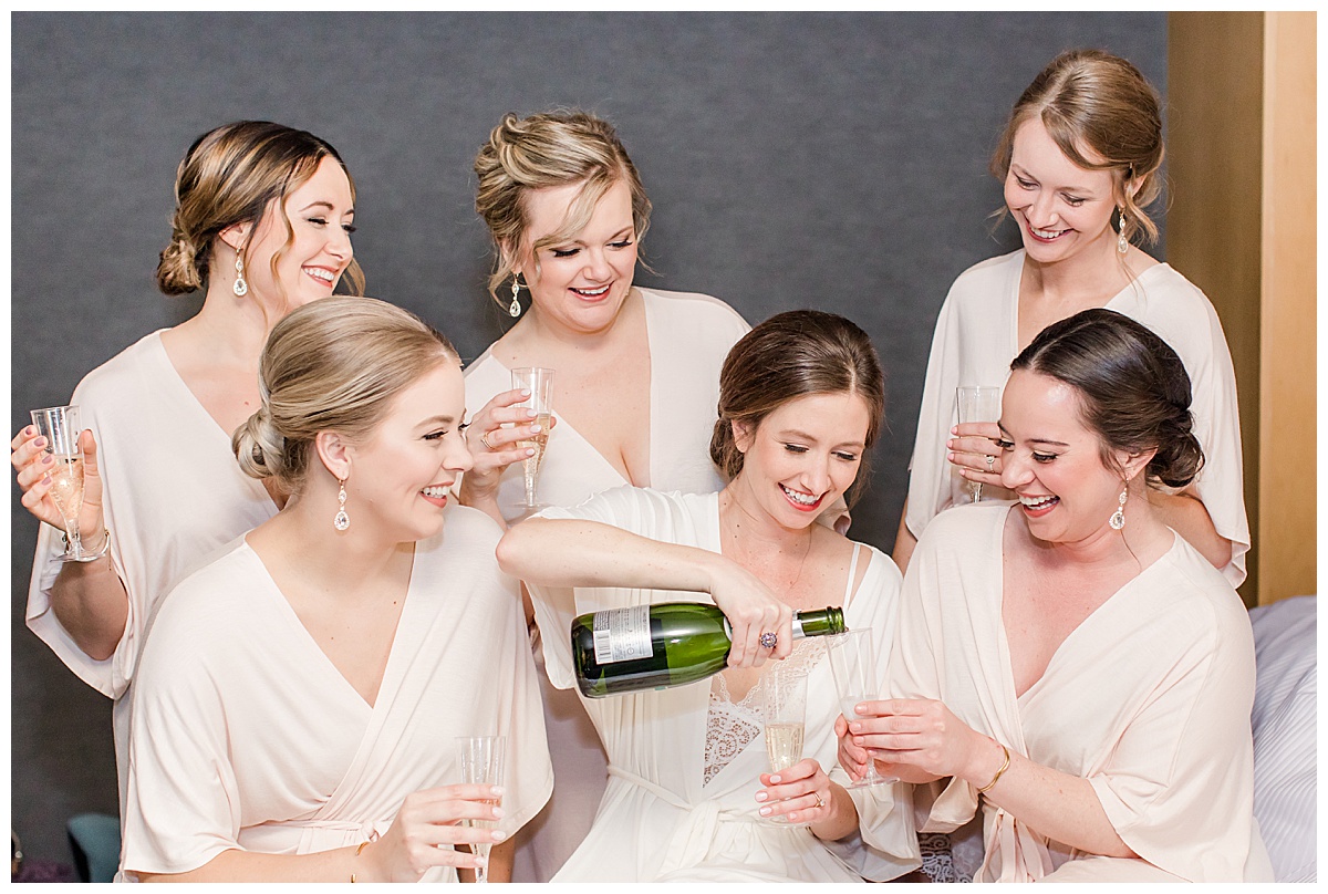 bridesmaids in robes pouring champagne