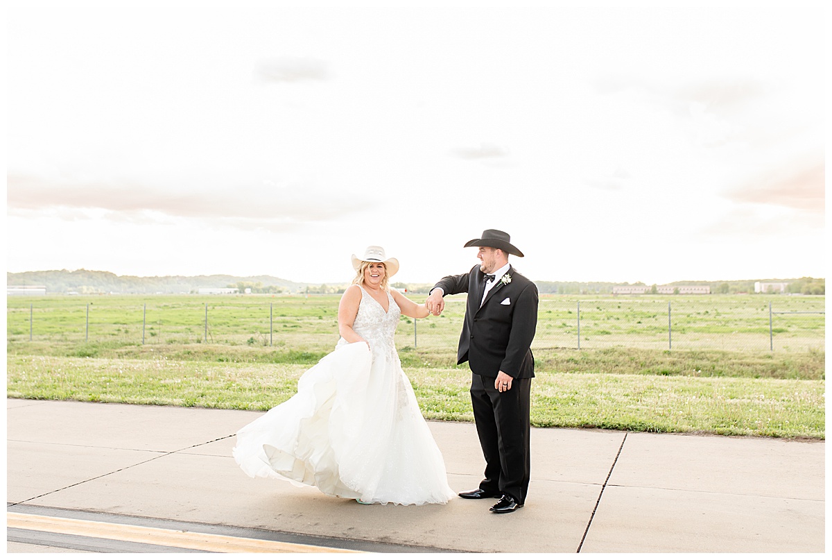 bride and groom dancing on airplane runway