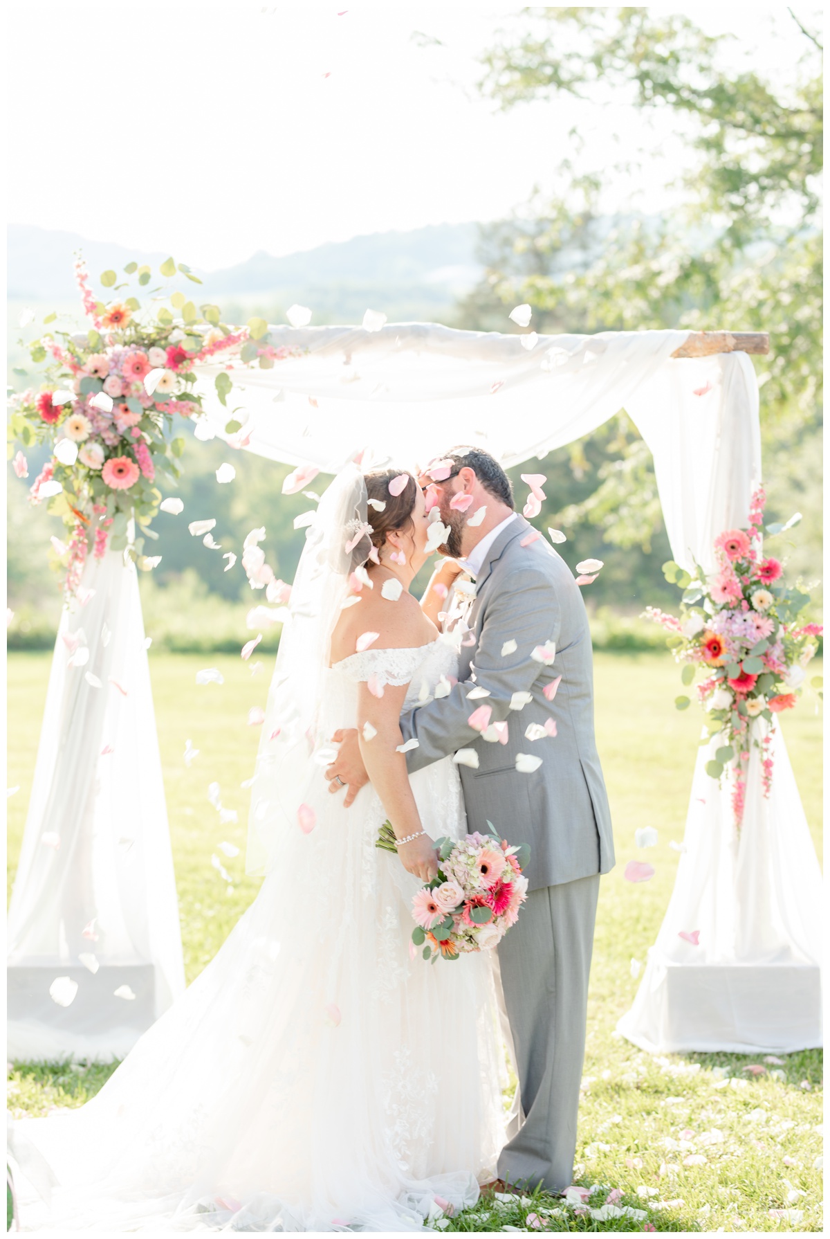 bride and groom kissing at Cedar Creek with flower petals