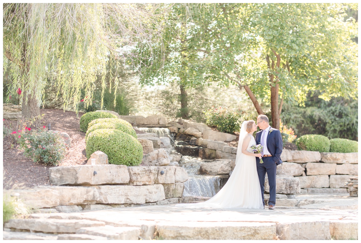 bride and groom at waterfall at cedar lake cellars