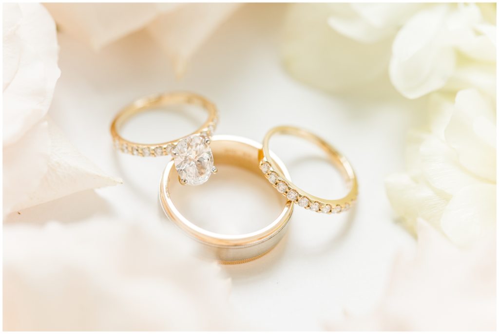 The bride's engagement ring and bot wedding bands are pictured on pale florals. 