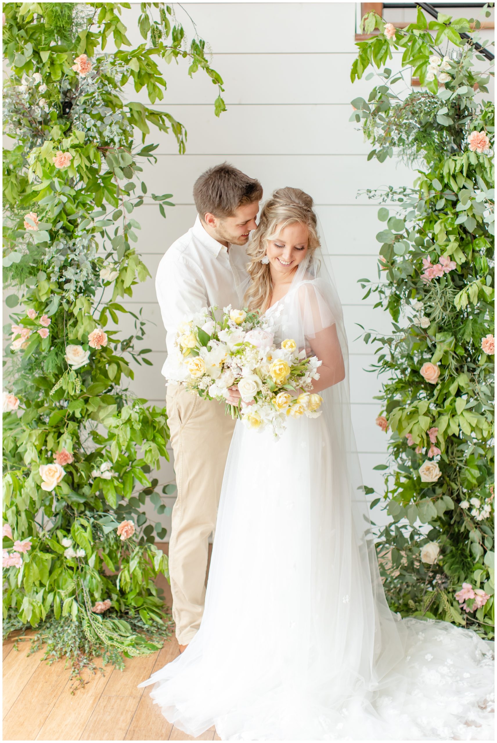 bride and groom under floral arch at Emerson Fields wedding venue