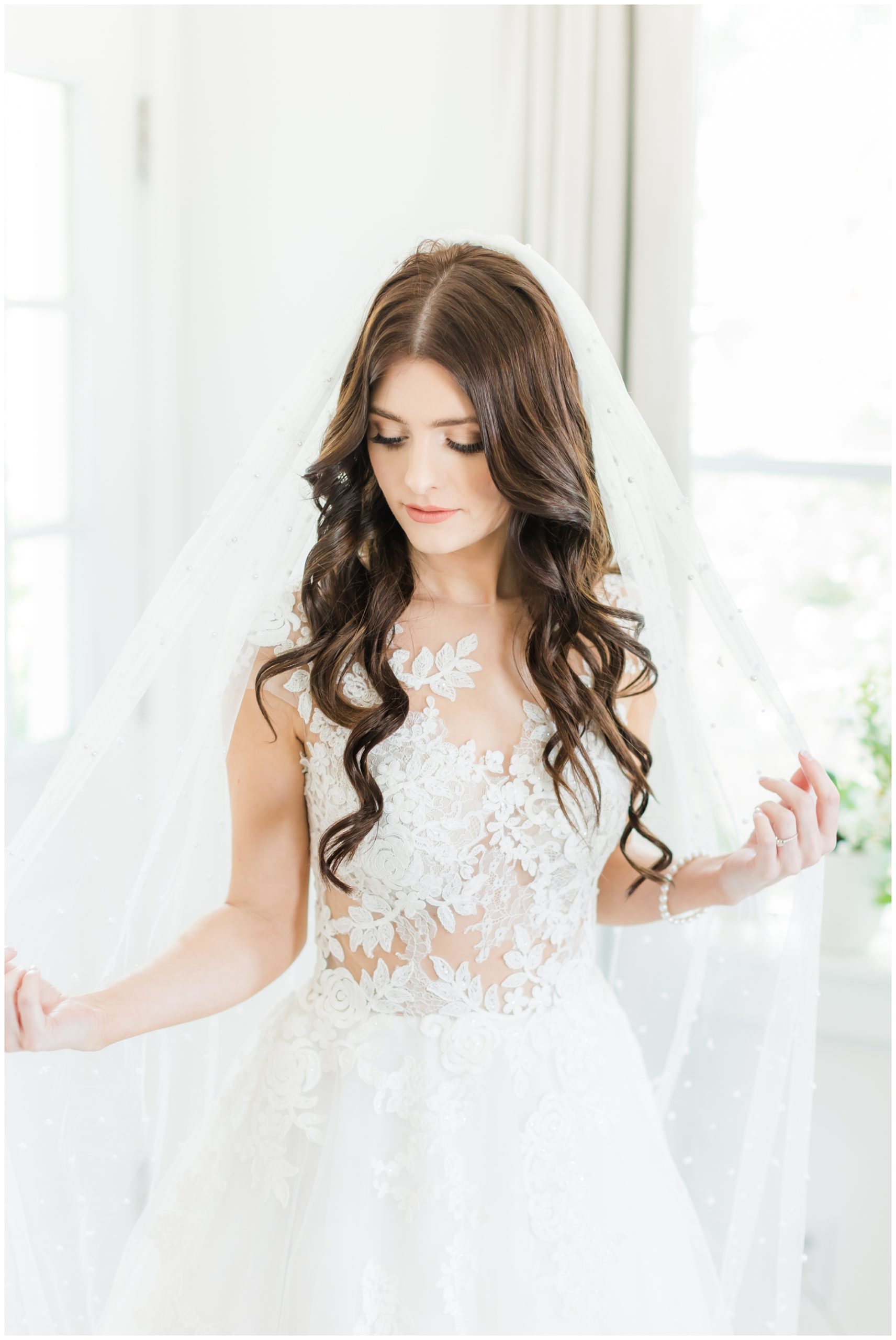 The bride poses in her white lace wedding dress. 