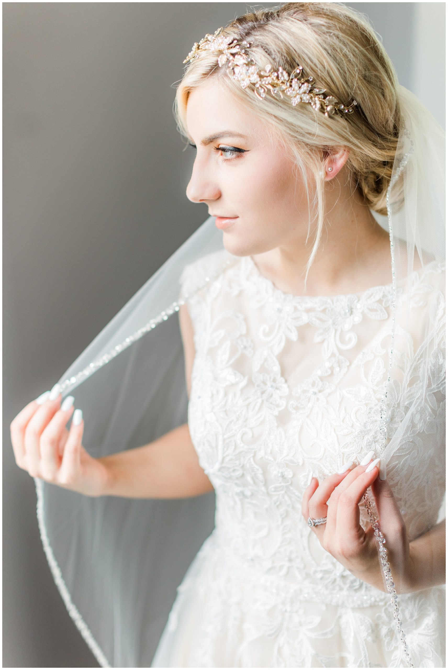 The bride gives a soft smile in a portrait in her gown. 