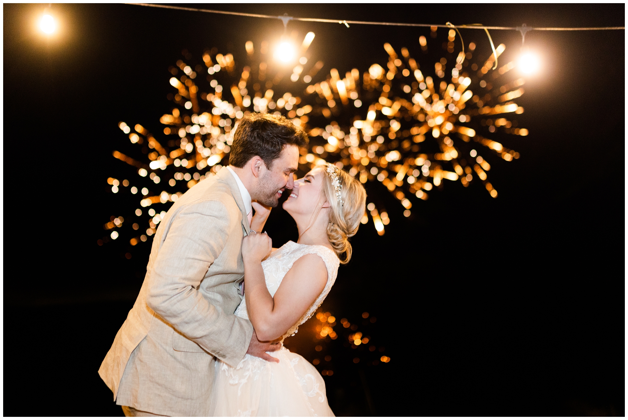 The bride and groom kiss in front of their private fireworks show. 