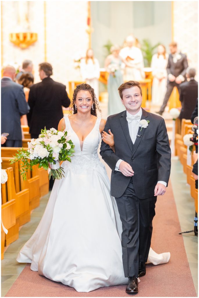 The bride and groom are all smiles as they leave their ceremony. 
