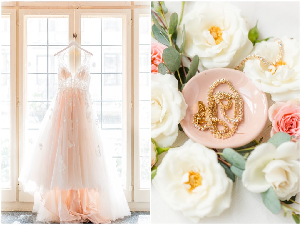 The bride's blush pink wedding dress is hanging in front of a window on a custom bridal hanger. 2nd picture: gold and crystal wedding jewelry sits in a light pink bowl and is also draped over her white and light pink wedding flowers. 