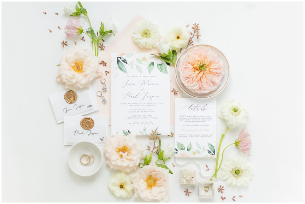 An English garden themed wedding invitation suite on a background of pale peach florals. 