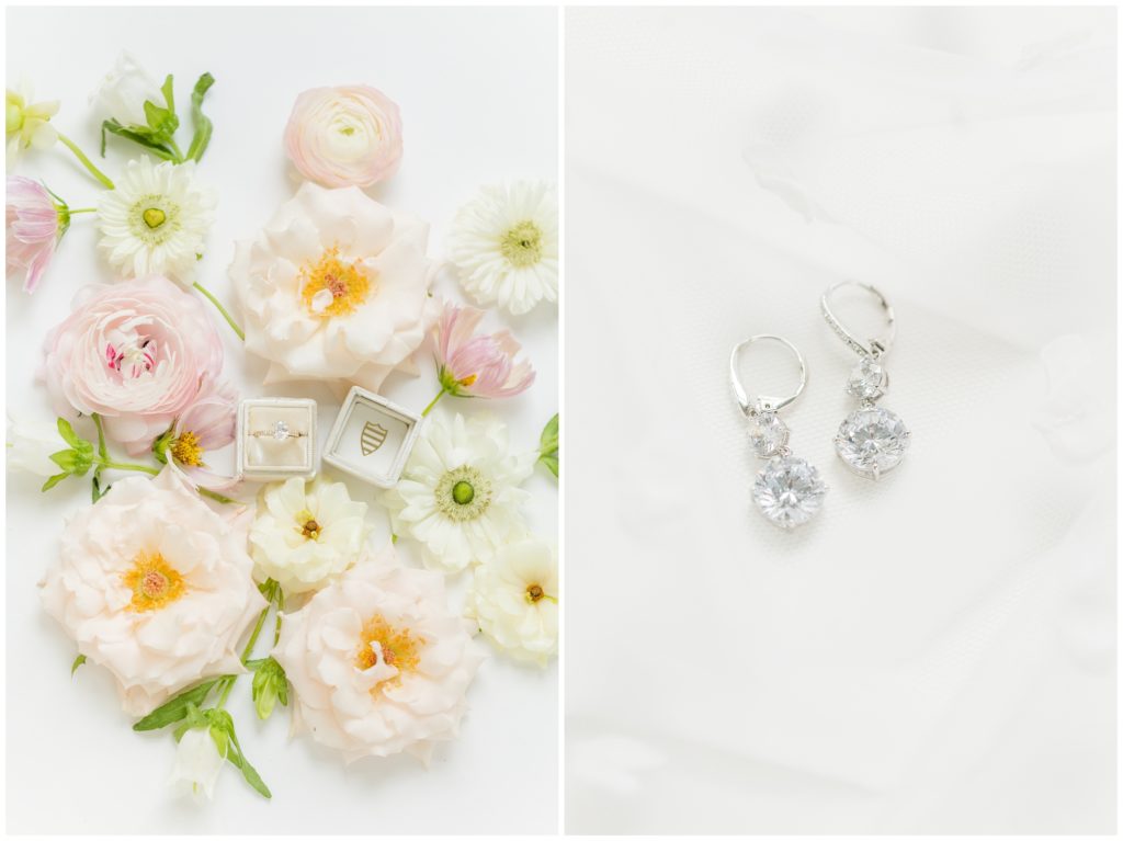 1st pic: The bride's diamond engagement ring is pictured in a cream velvet ring box, all on a background of pale florals. 2nd pic: The bride's diamond drop earrings are displayed on wedding veil. 