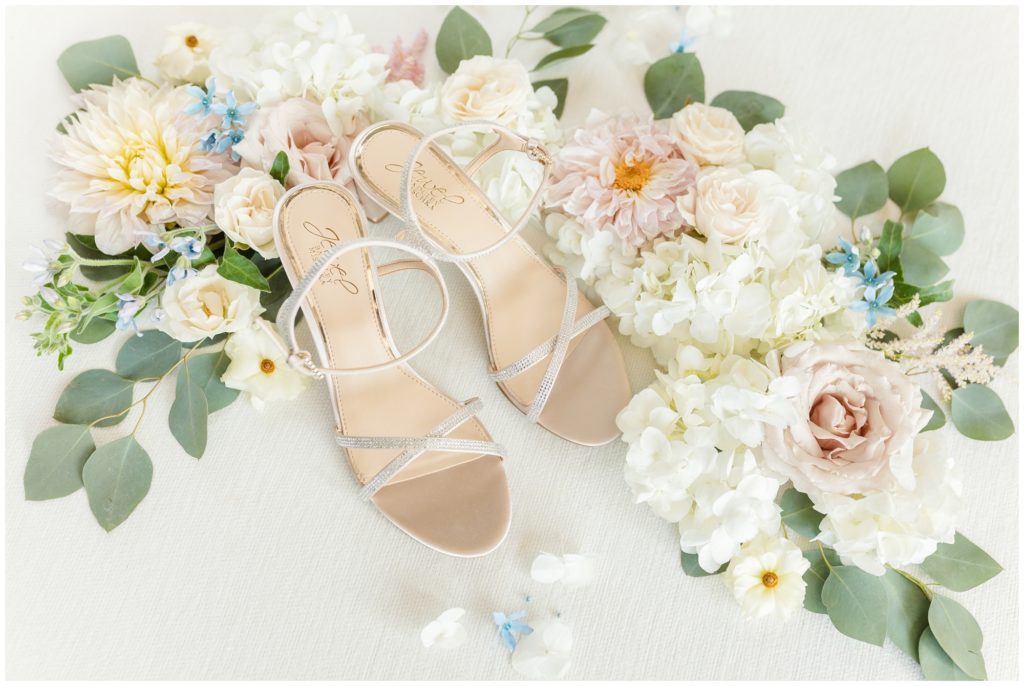 The bride's Badgley Mischka wedding shoes are displayed amongst the wedding flowers. 
